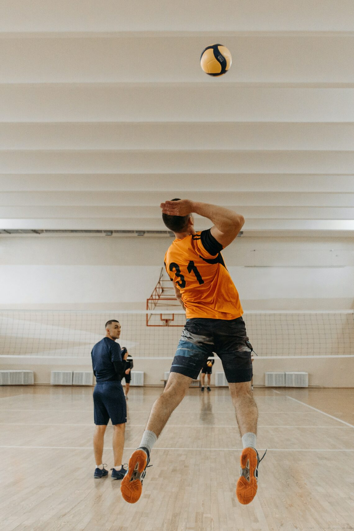 man hits jumping volleyball serve